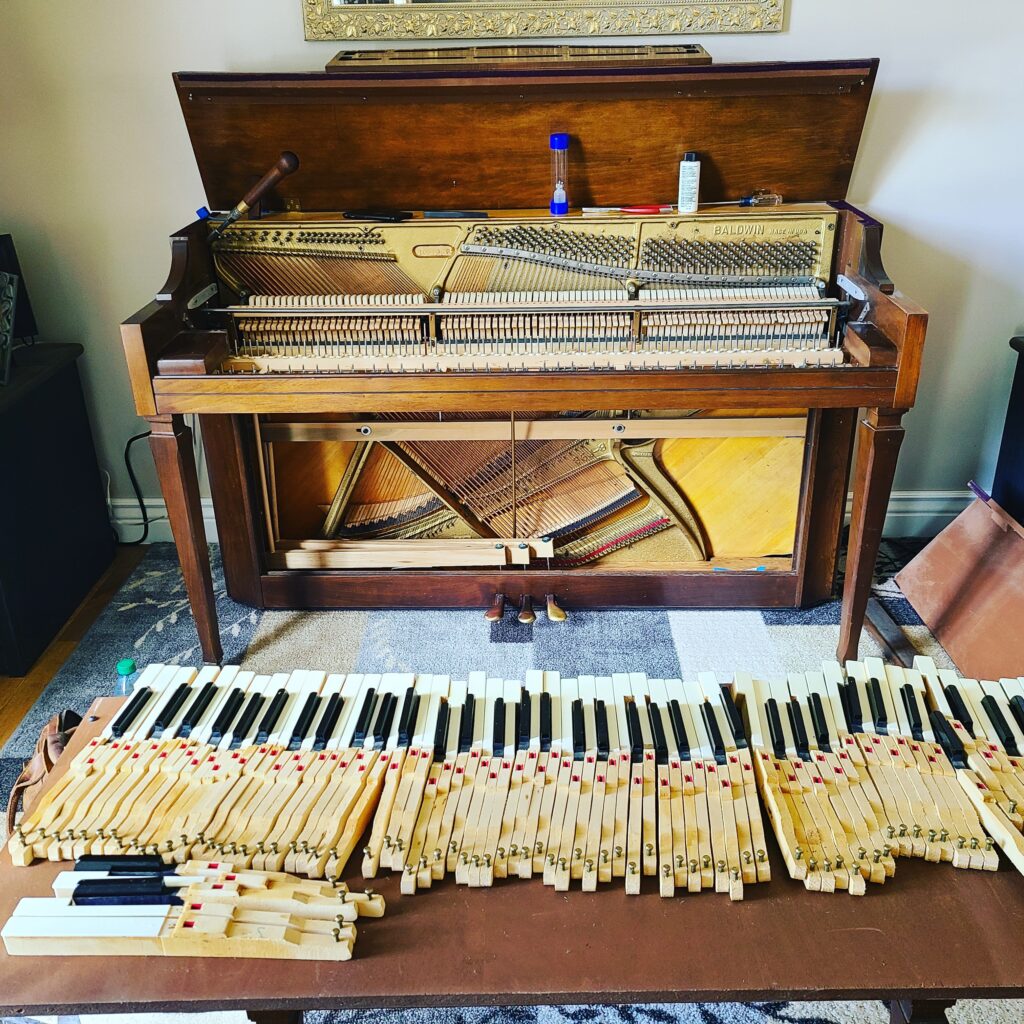 An upright piano being deep cleaned.